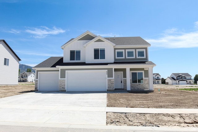 646 E 2475 N, North Logan, UT 84341 - view of front of home featuring covered porch, stone siding, concrete driveway, and a garage