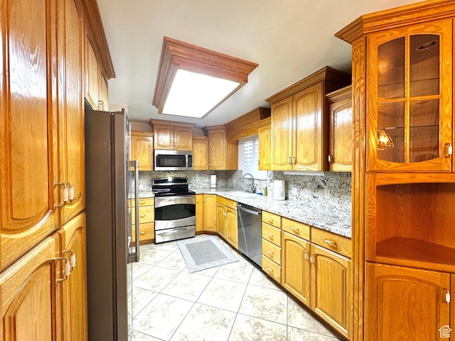 500 W Clark St S, Grantsville, UT 84029 - kitchen with light stone counters, appliances with stainless steel finishes, a sink, light tile patterned floors, and tasteful backsplash