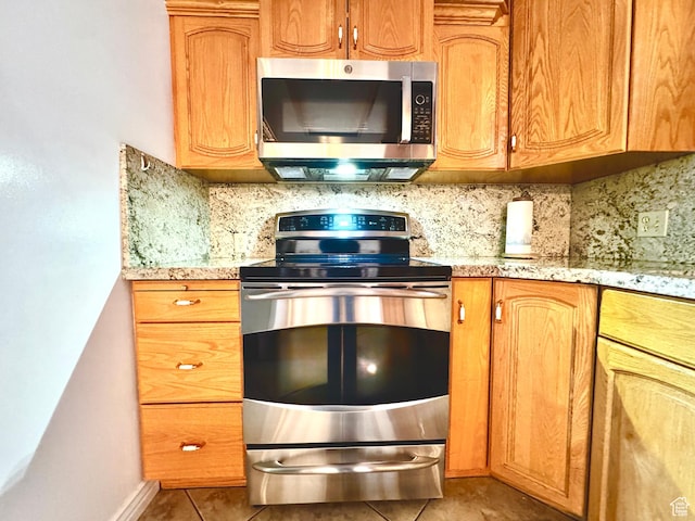 500 W Clark St S, Grantsville, UT 84029 - kitchen featuring stainless steel appliances, light stone countertops, decorative backsplash, and light tile patterned floors