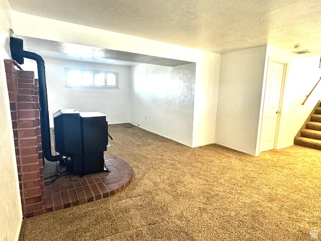 500 W Clark St S, Grantsville, UT 84029 - below grade area with stairway, carpet floors, a wood stove, and a textured ceiling