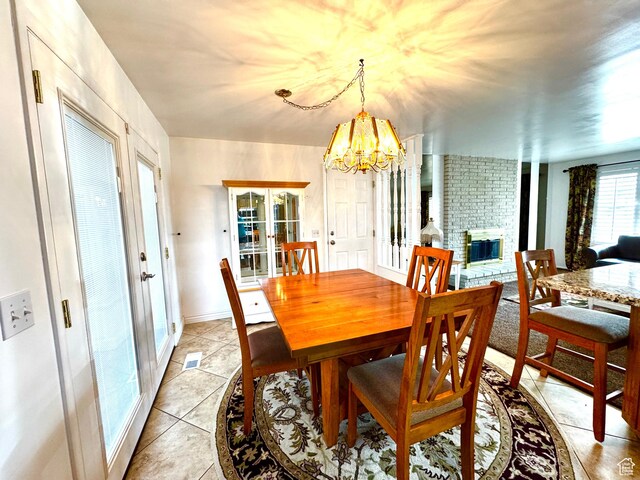 500 W Clark St S, Grantsville, UT 84029 - dining area featuring light tile patterned flooring, an inviting chandelier, a fireplace, french doors, and visible vents