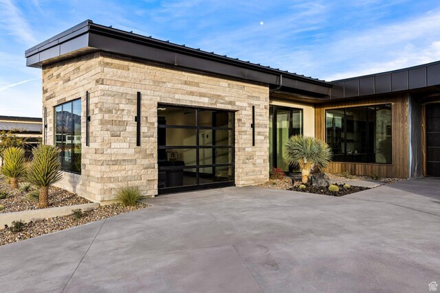 20 N Cliffside Dr, Washington, UT 84780 - property entrance featuring concrete driveway, stone siding, and an attached garage