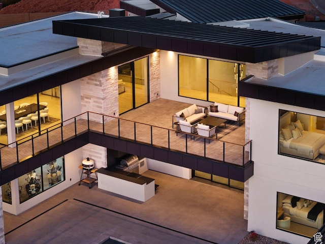 20 N Cliffside Dr, Washington, UT 84780 - back of house with a balcony, stone siding, an outdoor hangout area, and a patio