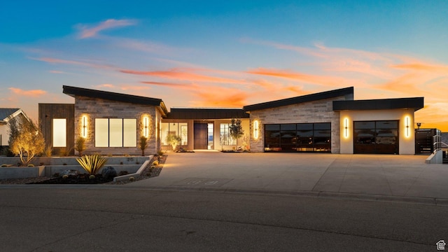 20 N Cliffside Dr, Washington, UT 84780 - contemporary house featuring a garage, stone siding, and concrete driveway
