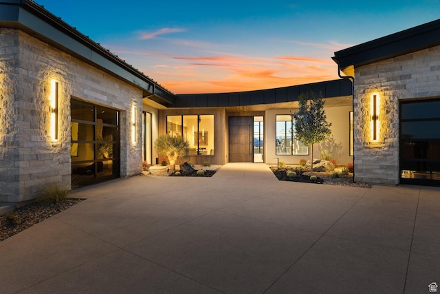 20 N Cliffside Dr, Washington, UT 84780 - rear view of house with a garage, concrete driveway, and stone siding
