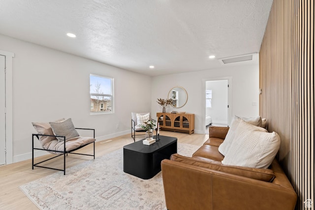living room featuring light hardwood / wood-style floors and a textured ceiling