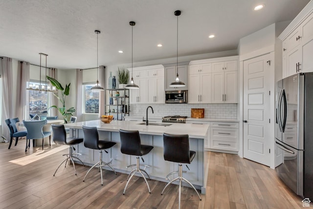 14203 S Brook Heights Cir W, Herriman, UT 84096 - kitchen featuring stainless steel appliances, hanging light fixtures, sink, and white cabinets