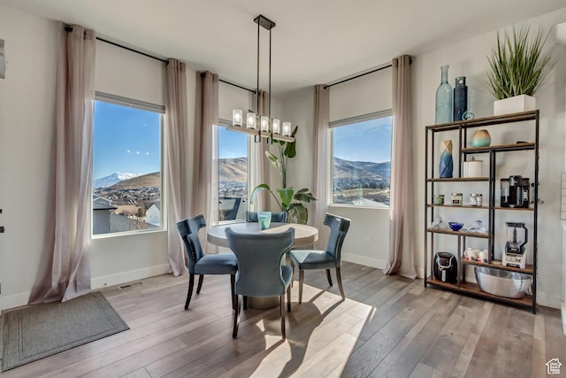 14203 S Brook Heights Cir W, Herriman, UT 84096 - dining space featuring a mountain view, a wealth of natural light, an inviting chandelier, and light hardwood / wood-style floors