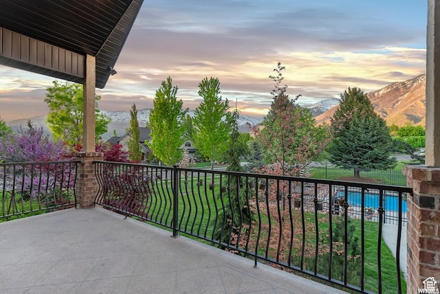 balcony at dusk featuring a mountain view