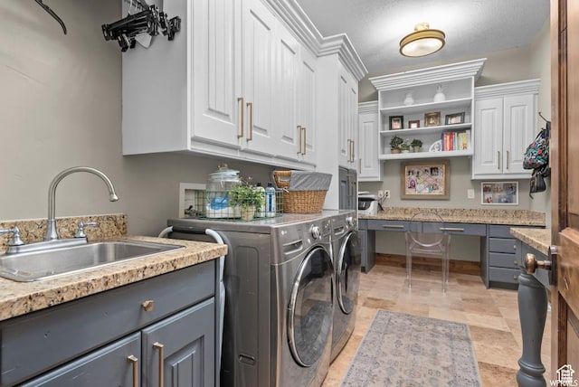 laundry area featuring cabinets, washer and clothes dryer, and sink