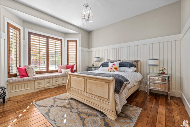 bedroom featuring a notable chandelier and dark wood-type flooring