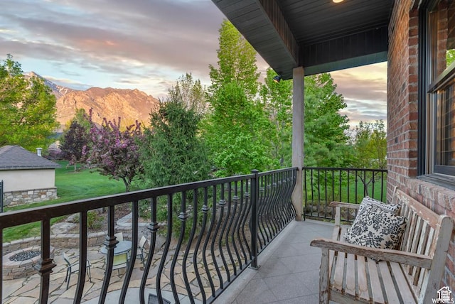 balcony at dusk featuring a mountain view