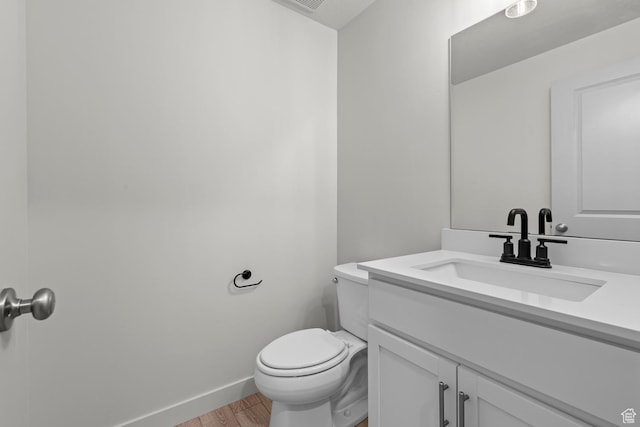 bathroom with vanity, toilet, and wood-type flooring
