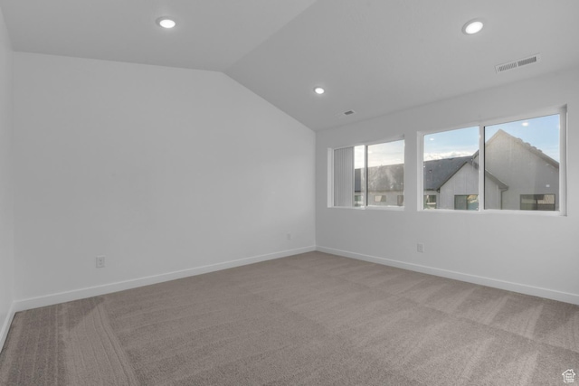 spare room with lofted ceiling and carpet floors
