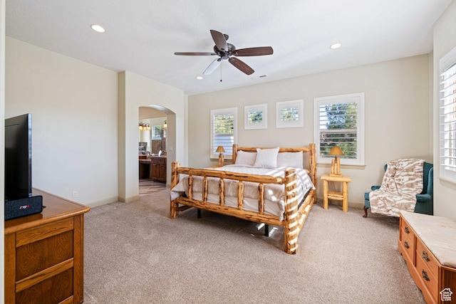 carpeted bedroom featuring ensuite bath and ceiling fan