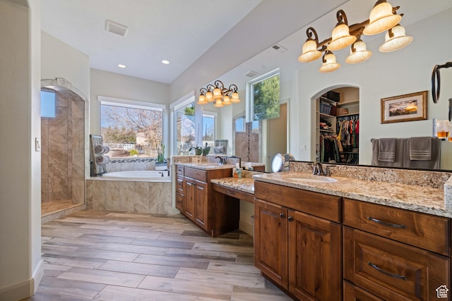 bathroom with vanity, hardwood / wood-style floors, and separate shower and tub