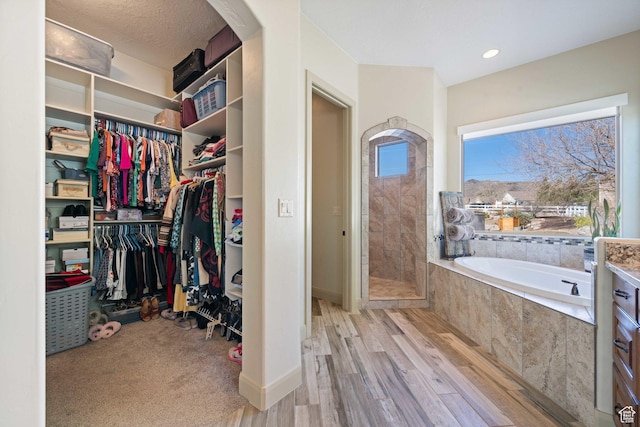 1512 Cholla Dr, Toquerville, UT 84774 - bathroom with a garden tub, wood finished floors, a tile shower, and a walk in closet