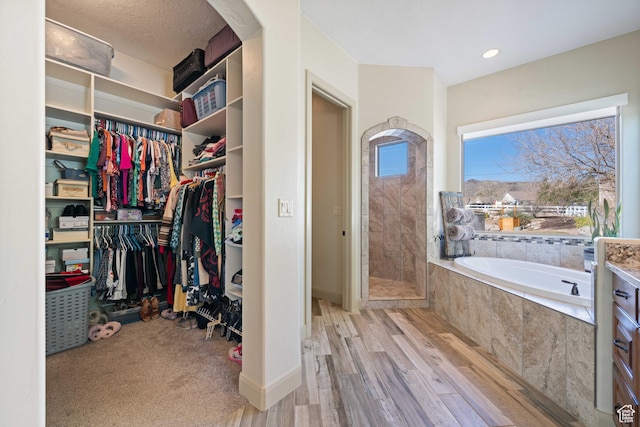 bathroom with independent shower and bath and hardwood / wood-style flooring