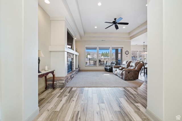 1512 Cholla Dr, Toquerville, UT 84774 - living area with light wood-style flooring, a tray ceiling, ceiling fan, a fireplace, and recessed lighting