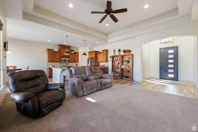 1512 Cholla Dr, Toquerville, UT 84774 - living room with arched walkways, a raised ceiling, a ceiling fan, recessed lighting, and light wood-style flooring