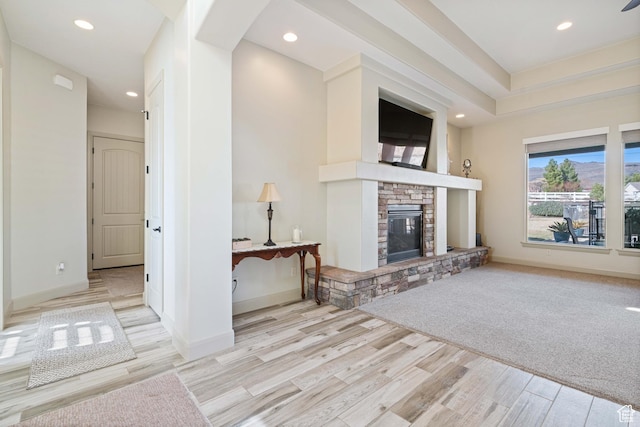 unfurnished living room featuring a stone fireplace and light wood-type flooring
