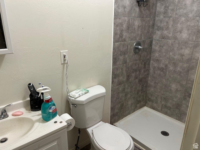 bathroom featuring sink, toilet, and tiled shower