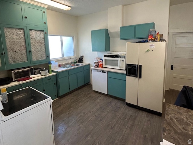 kitchen with sink, white appliances, green cabinetry, and dark hardwood / wood-style flooring