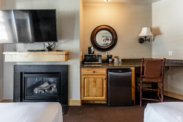2669 N Canyons Resort Dr W Unit 205, Park City, UT 84098 - bar with a textured wall, freestanding refrigerator, a glass covered fireplace, and dark carpet