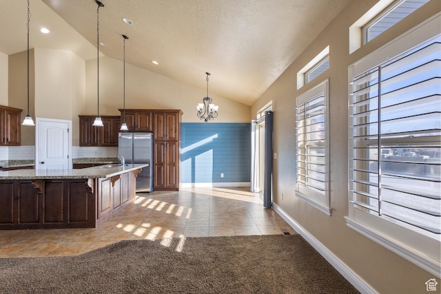 11513 S Jackson Downs Way S, Jordan, UT 84095 - kitchen with light tile patterned flooring, decorative light fixtures, a breakfast bar area, stainless steel fridge, and a chandelier