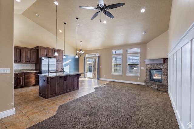 11513 S Jackson Downs Way S, Jordan, UT 84095 - kitchen featuring a breakfast bar area, a center island with sink, light colored carpet, and stainless steel refrigerator