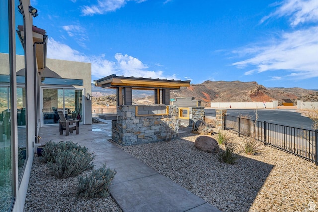 exterior space featuring a mountain view, a fenced backyard, a patio, and area for grilling