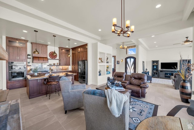 living room featuring light tile patterned floors, built in features, a raised ceiling, recessed lighting, and ceiling fan with notable chandelier