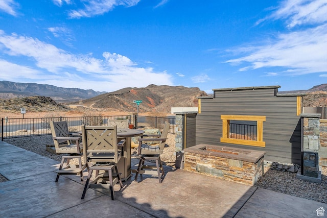 view of patio / terrace with outdoor dining space, a mountain view, and fence
