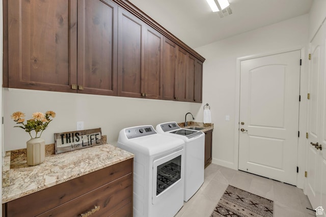 clothes washing area with separate washer and dryer, light tile patterned floors, visible vents, cabinet space, and a sink
