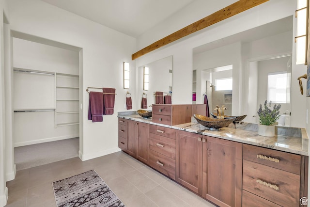 bathroom featuring a spacious closet, tile patterned floors, vanity, and baseboards
