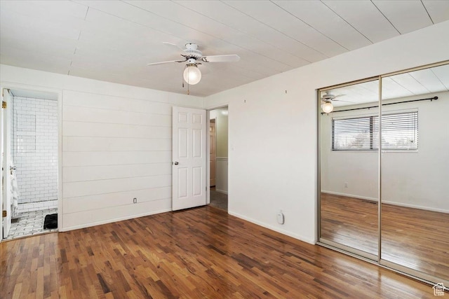 unfurnished bedroom with ceiling fan, dark hardwood / wood-style floors, ensuite bath, and a closet
