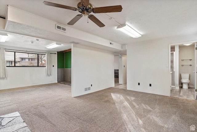 carpeted spare room with ceiling fan and a textured ceiling