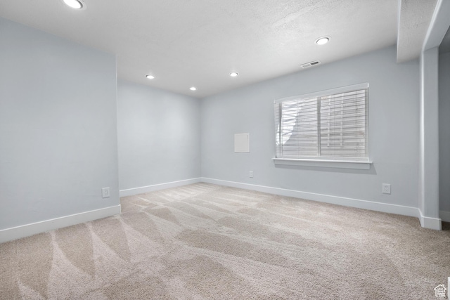 carpeted spare room featuring baseboards, recessed lighting, and visible vents