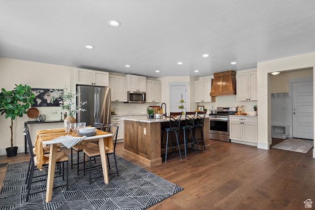 kitchen featuring stainless steel appliances, premium range hood, recessed lighting, and dark wood-style floors