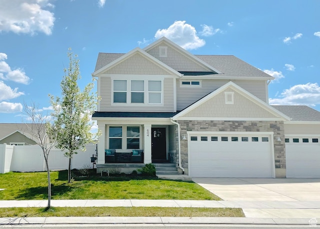 craftsman inspired home with an attached garage, covered porch, fence, a front lawn, and driveway