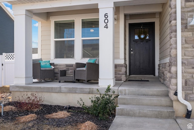 entrance to property with stone siding and a porch