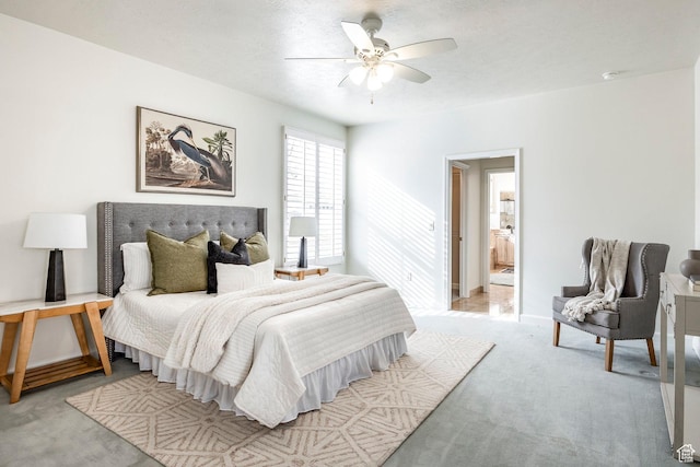 bedroom featuring ceiling fan, light colored carpet, and a textured ceiling