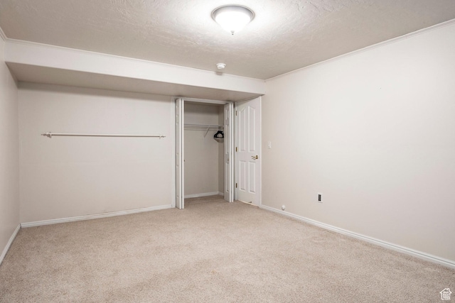 unfurnished bedroom with light colored carpet, a closet, and a textured ceiling