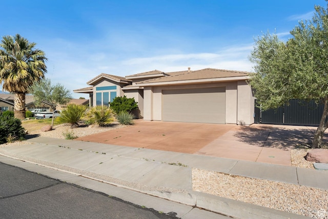 3523 S Desert Hills Dr, St George, UT 84790 - view of front of house with concrete driveway, an attached garage, a tile roof, and stucco siding