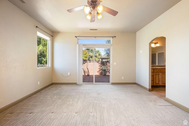 3523 S Desert Hills Dr, St George, UT 84790 - empty room featuring baseboards, light carpet, visible vents, ceiling fan, and arched walkways