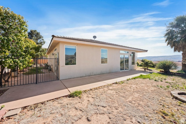 3523 S Desert Hills Dr, St George, UT 84790 - rear view of property featuring fence, a patio area, stucco siding, and a gate