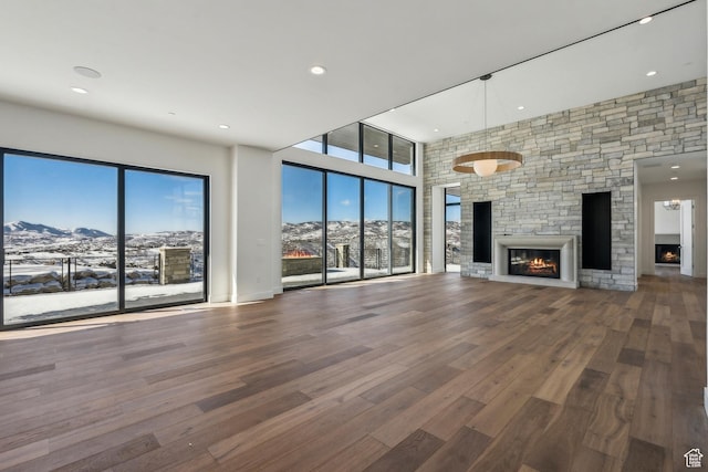 2738 Longspur Ln, Park City, UT 84098 - unfurnished living room with a healthy amount of sunlight, a stone fireplace, a mountain view, and hardwood / wood-style floors
