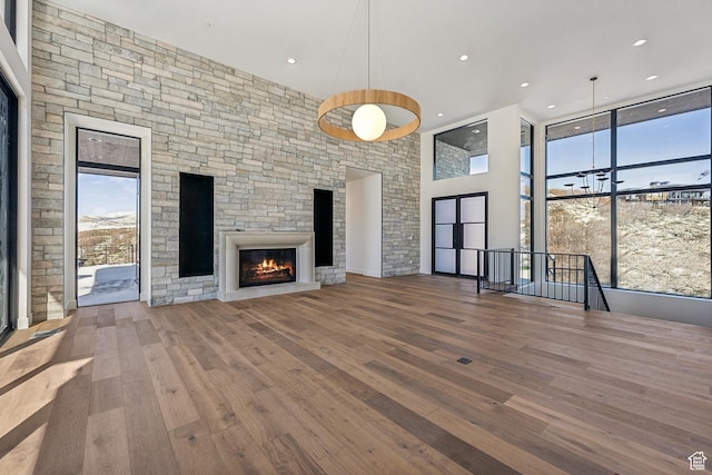 2738 Longspur Ln, Park City, UT 84098 - unfurnished living room with expansive windows, a towering ceiling, hardwood / wood-style floors, and a fireplace