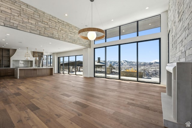2738 Longspur Ln, Park City, UT 84098 - unfurnished living room with wood-type flooring, a mountain view, and a towering ceiling