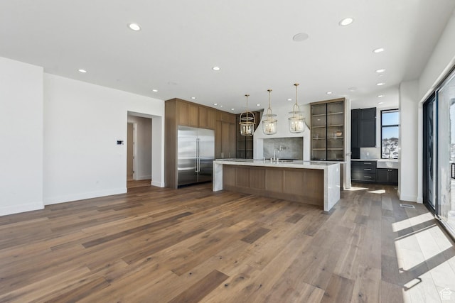 2738 Longspur Ln, Park City, UT 84098 - kitchen with dark wood-type flooring, stainless steel built in refrigerator, sink, hanging light fixtures, and a large island